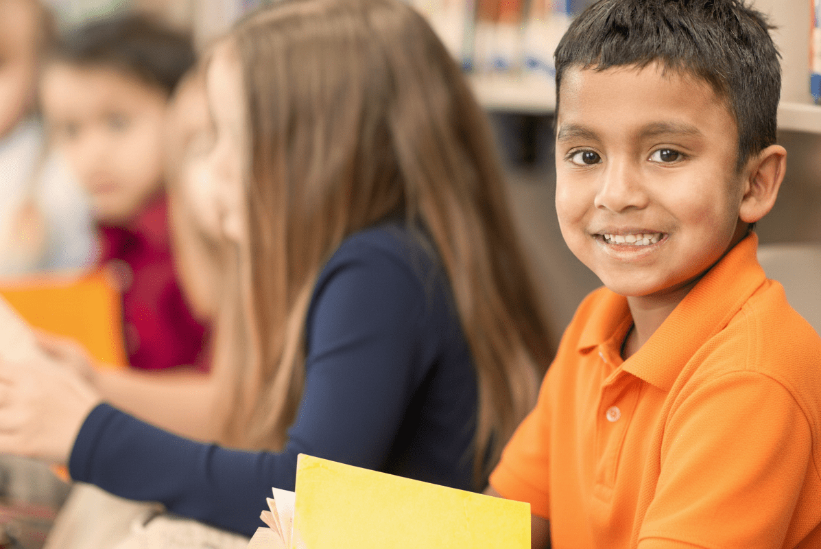 Smiling student reading at desk