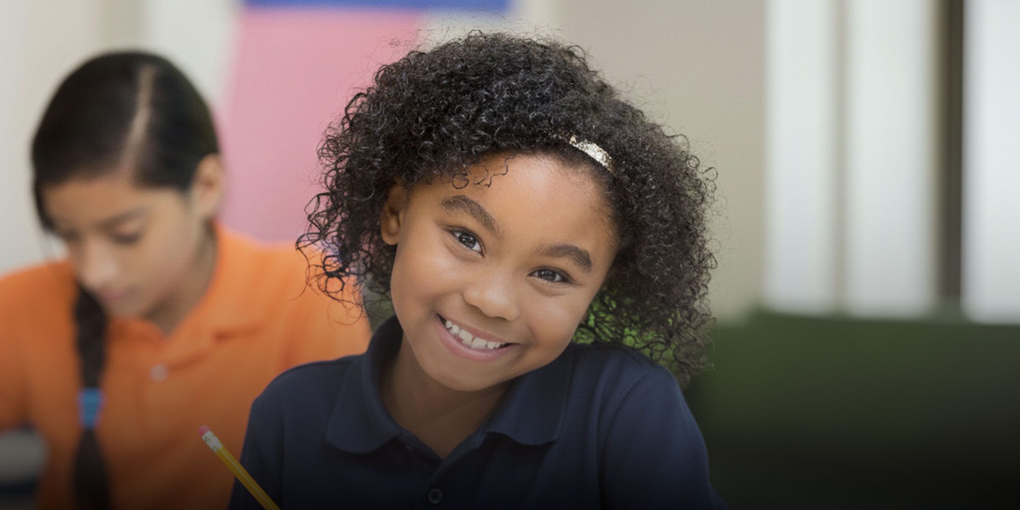 Smiling student writing at desk
